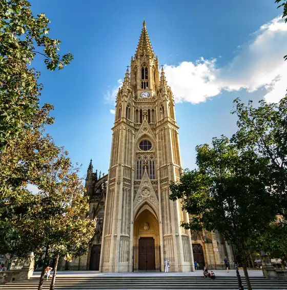 Torre da catedral do Bom Pastor entre árvores, em San Sebastián